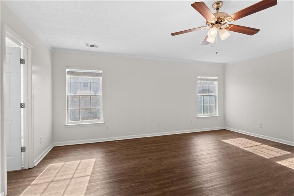 2068 White Top Road Southeast Lawrenceville, GA 30045 - Photo 23 of 41 an empty room with wooden floor chandelier fan and windows