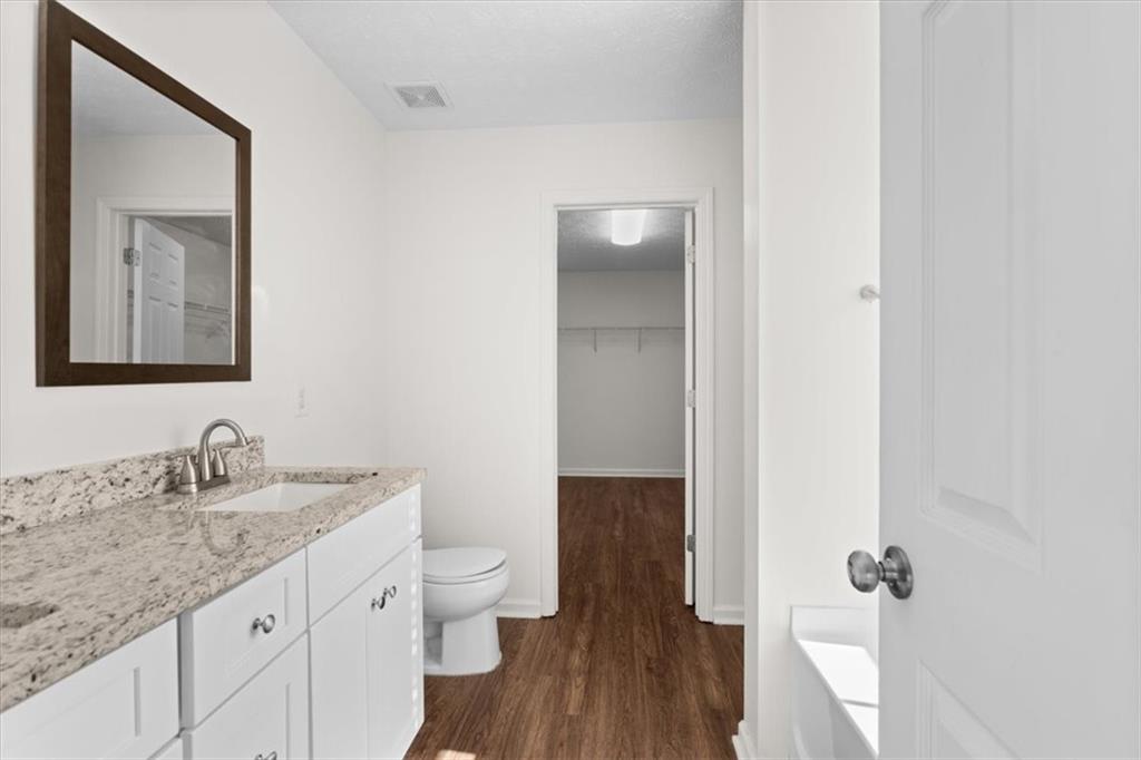 2068 White Top Road Southeast Lawrenceville, GA 30045 - Photo 25 of 41 a bathroom with a granite countertop sink toilet and mirror