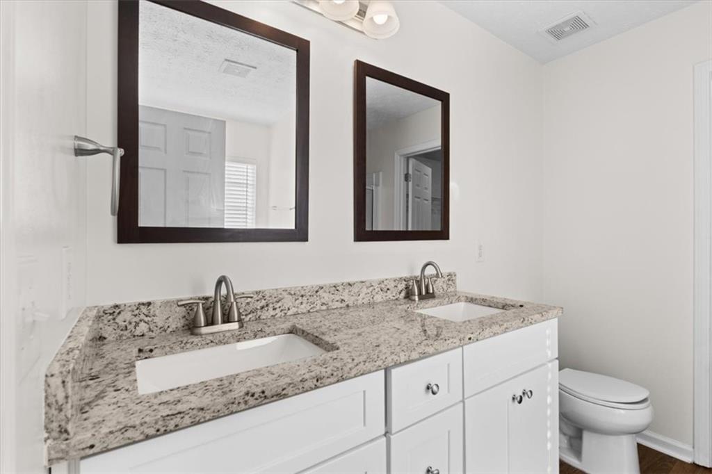 2068 White Top Road Southeast Lawrenceville, GA 30045 - Photo 26 of 41 a bathroom with a granite countertop sink and a toilet