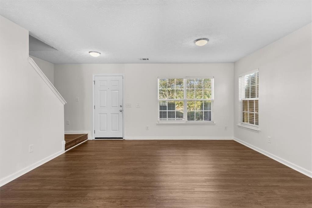 2068 White Top Road Southeast Lawrenceville, GA 30045 - Photo 6 of 41 an empty room with wooden floor and windows