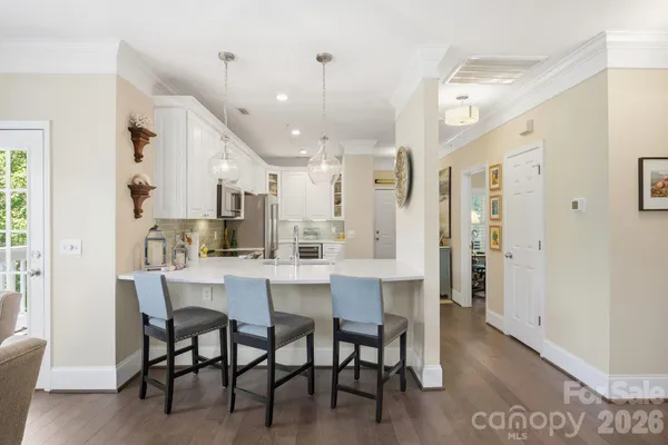 a dining room with stainless steel appliances a table and chairs