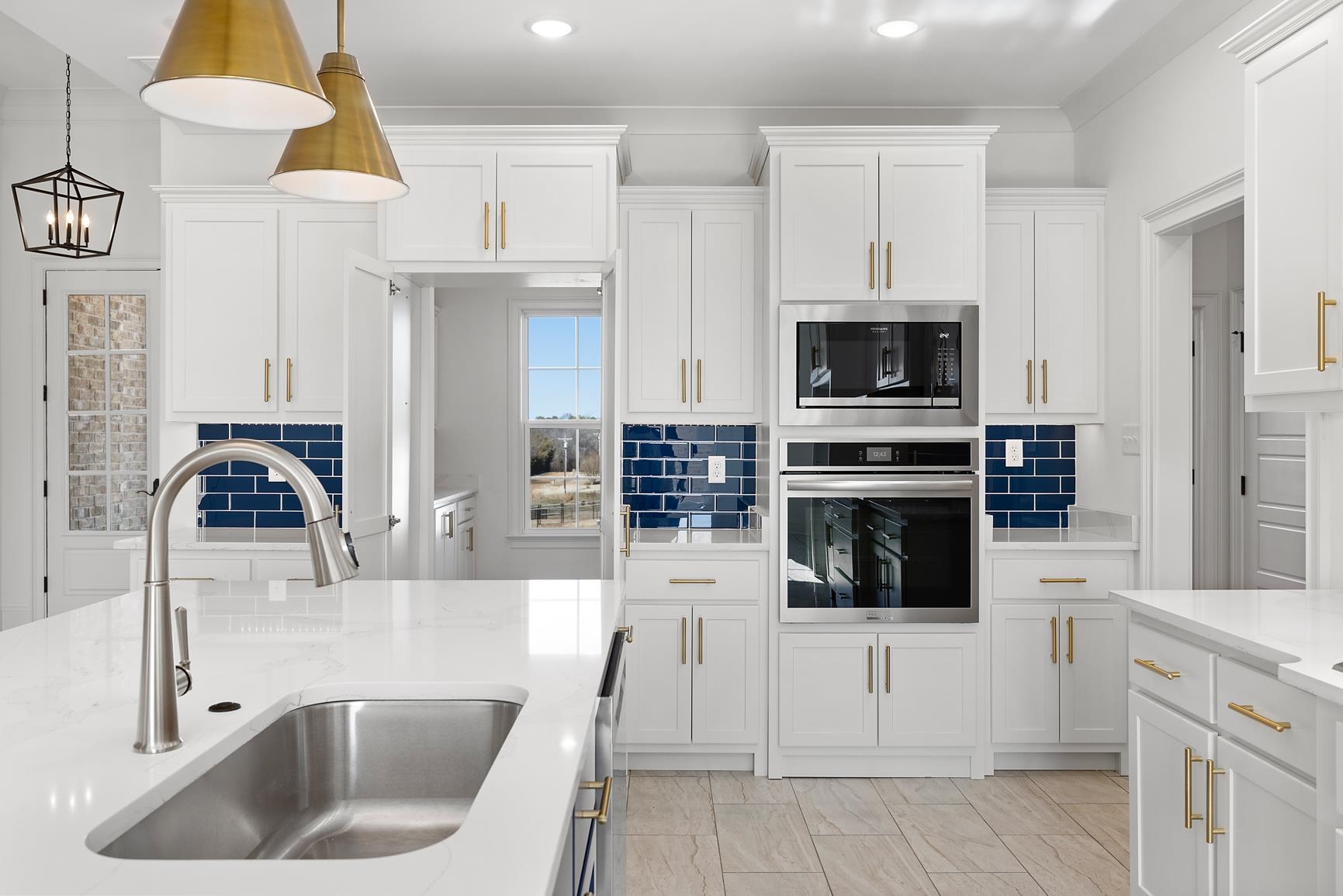 822 Leta Loop Brighton, TN 38011 - Photo 18 of 40 a kitchen with stainless steel appliances a stove a sink a microwave a refrigerator and cabinets