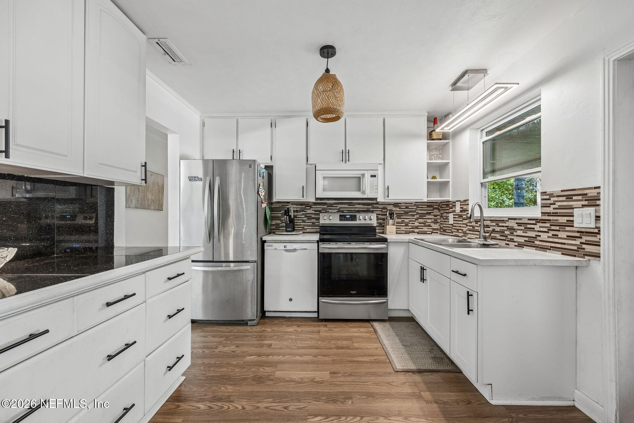 5136 Eulace Road Jacksonville, FL 32210 - Photo 11 of 41 a kitchen with white cabinets and stainless steel appliances