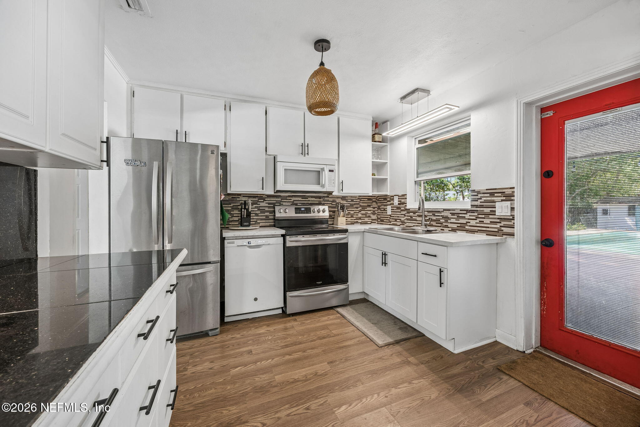 5136 Eulace Road Jacksonville, FL 32210 - Photo 13 of 41 a kitchen with stainless steel appliances kitchen island granite countertop a stove a sink and a refrigerator