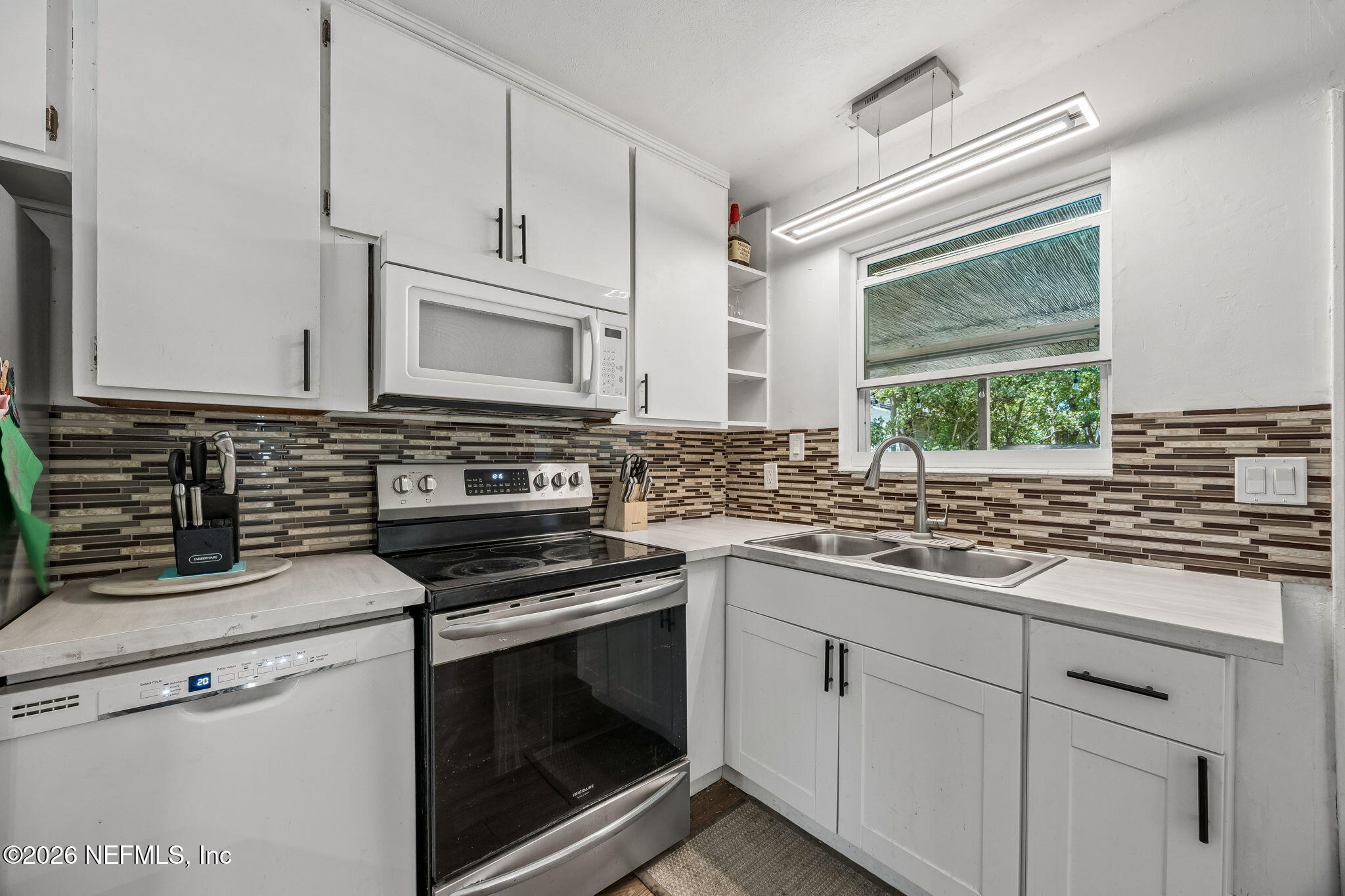 5136 Eulace Road Jacksonville, FL 32210 - Photo 14 of 41 a kitchen with white cabinets and appliances