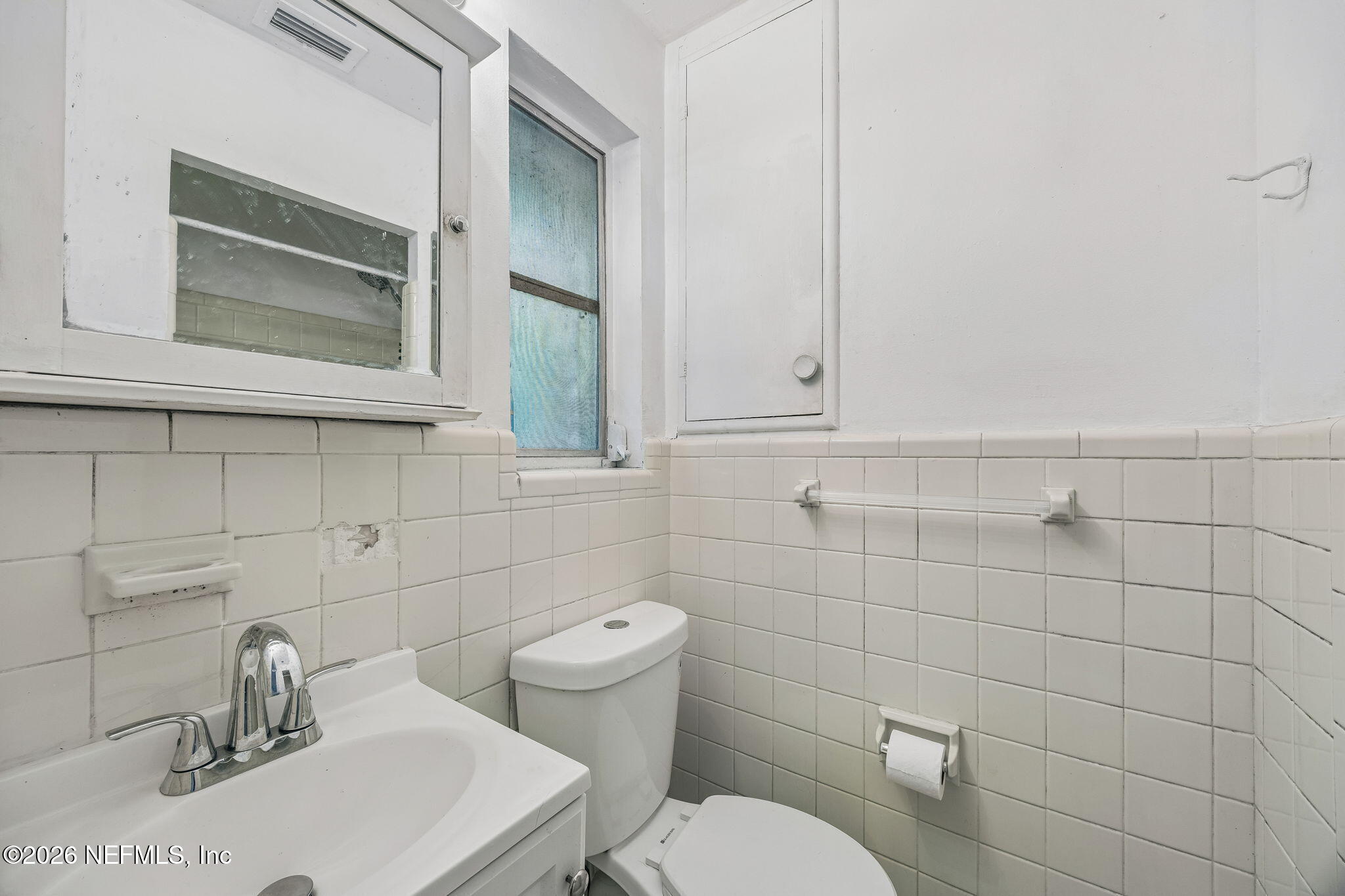 5136 Eulace Road Jacksonville, FL 32210 - Photo 18 of 41 a bathroom with a toilet sink and mirror