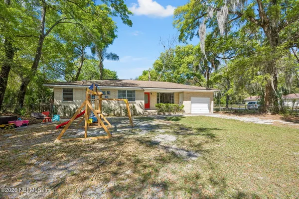 a view of a house with a yard and sitting area