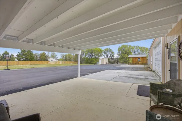 a living room with furniture kitchen view and a wooden floor