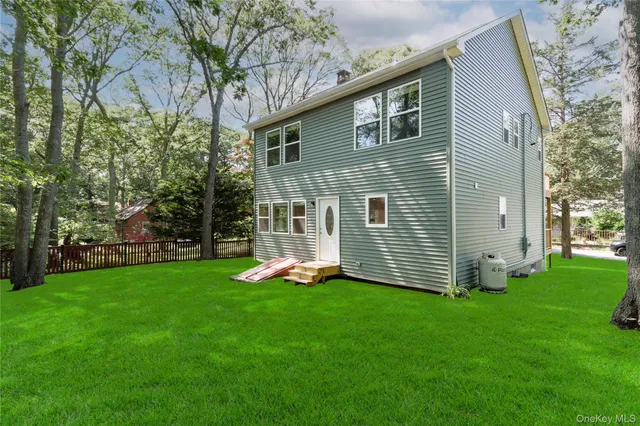 a front view of a house with a yard and tree