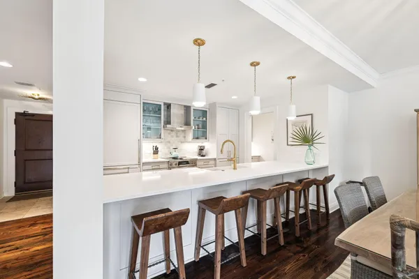 a kitchen with white cabinets and sink