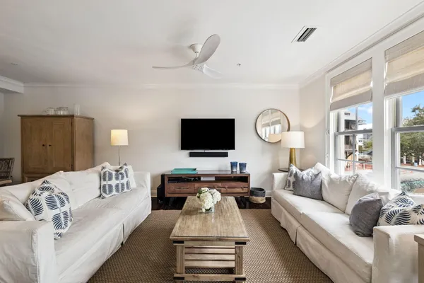 a living room with furniture a large window and a flat screen tv