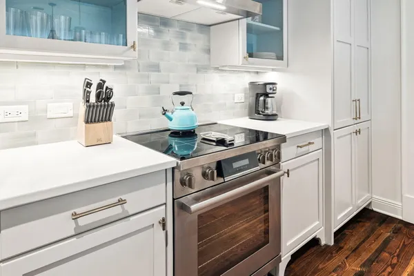a kitchen with kitchen island a dining table chairs and a chandelier