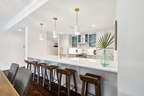 a kitchen with stainless steel appliances granite countertop a stove and a white cabinets