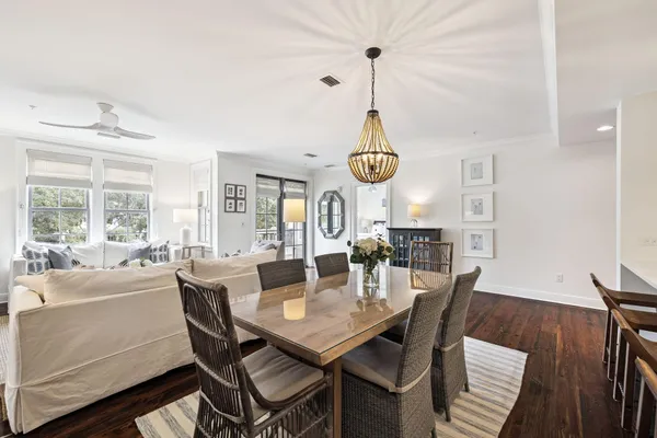 a view of a dining room and livingroom with furniture wooden floor a chandelier