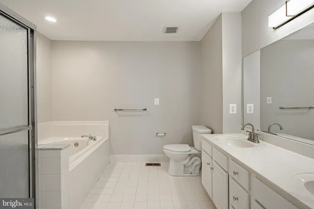 a bathroom with a double vanity sink toilet and shower