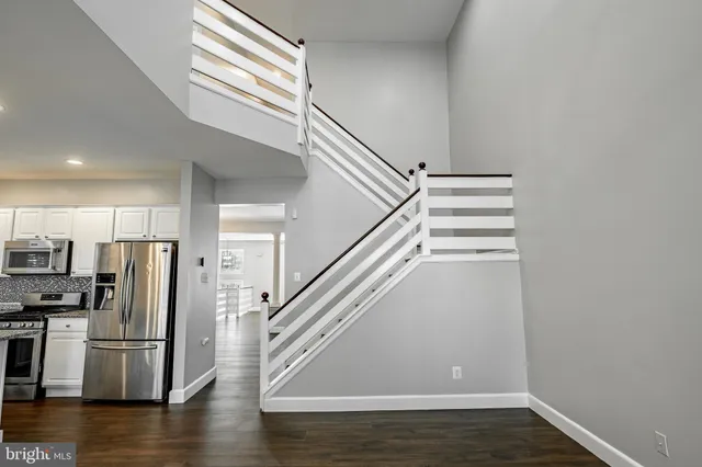 a view of entryway and kitchen with wooden floor