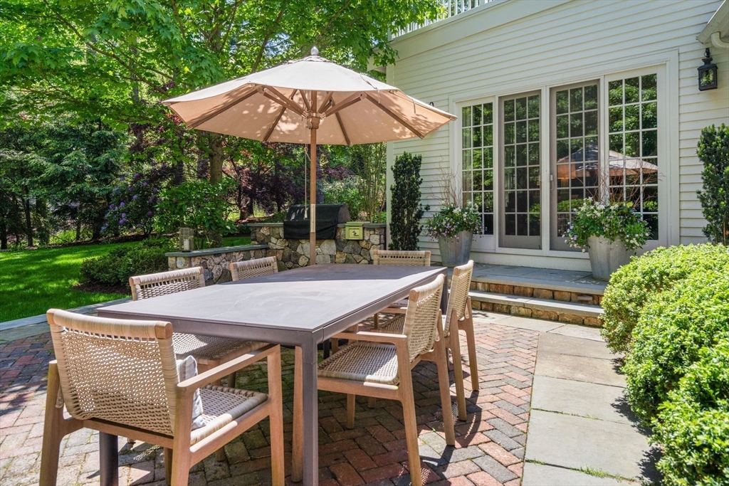 48 Scotch Pine Road Wellesley, MA 02481 - Photo 34 of 39 a patio with a table and chairs under an umbrella