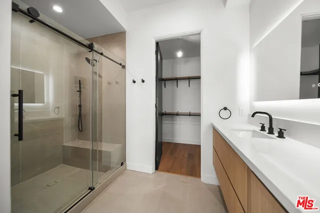 a spacious bathroom with a double vanity sink and mirror