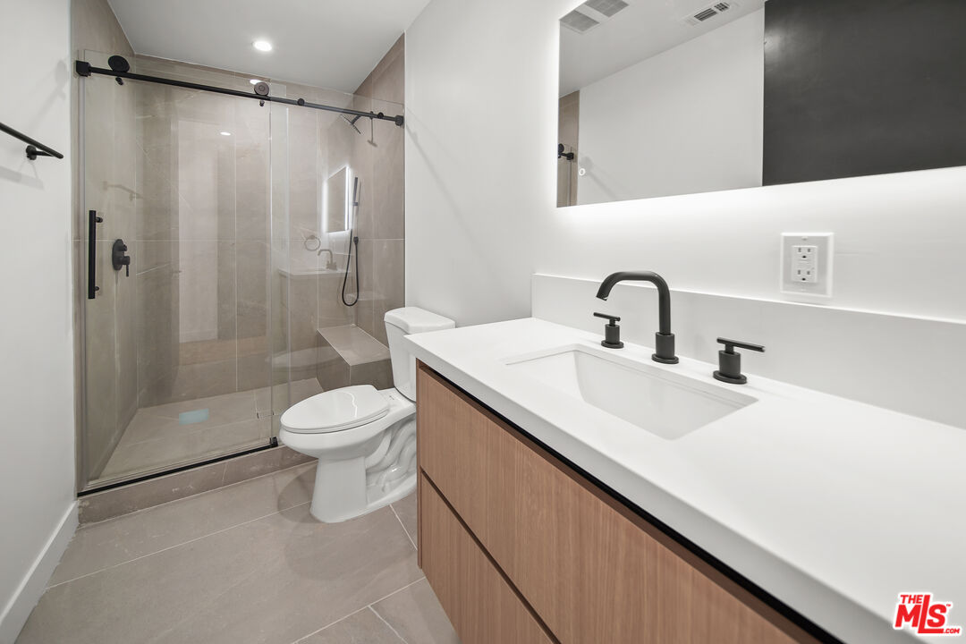 1905 South Corning Street, Unit 2 Los Angeles, CA 90034 - Photo 22 of 26 a bathroom with a sink toilet a mirror and shower