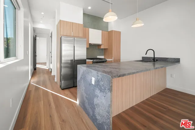 a kitchen with stainless steel appliances granite countertop a refrigerator a sink and a stove