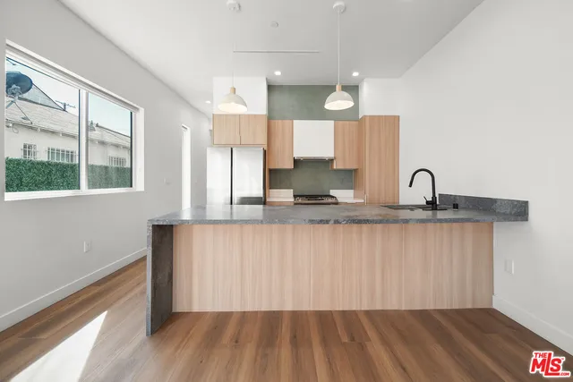 a kitchen with a sink wooden floor and a window