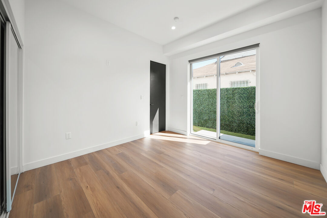 1905 South Corning Street, Unit 2 Los Angeles, CA 90034 - Photo 9 of 26 a view of an empty room with wooden floor and a window