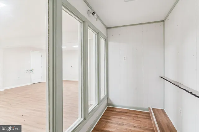 a view of a hallway with wooden floor and staircase