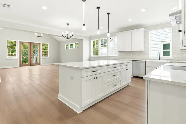 a kitchen with kitchen island granite countertop a sink a center island and cabinets