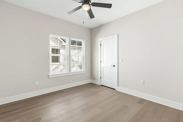 an empty room with a window and a fan