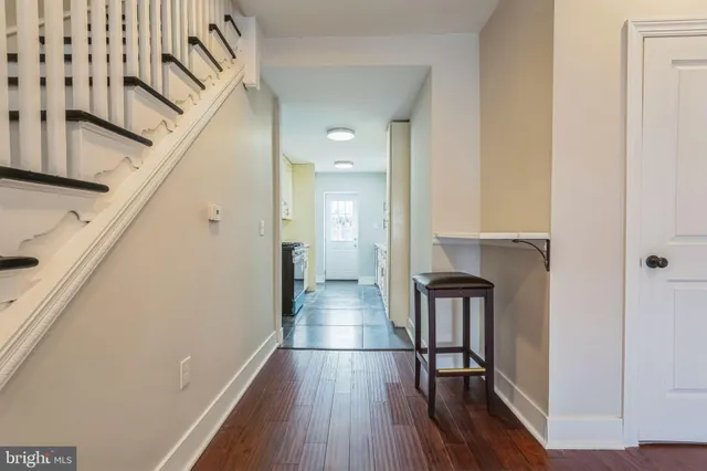 a view of a hallway with wooden floor and staircase