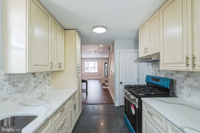 a kitchen with granite countertop a sink stove and cabinets