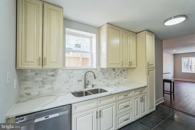a kitchen with white cabinets and sink