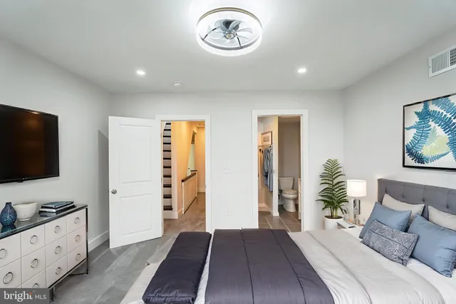 a spacious bedroom with a bed and a flat screen tv