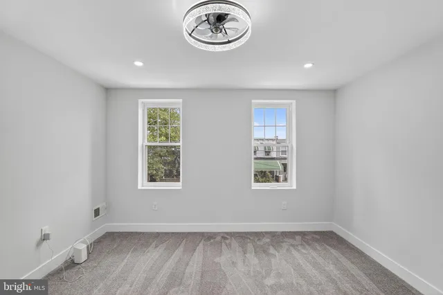 an empty room with a window and a wooden floor