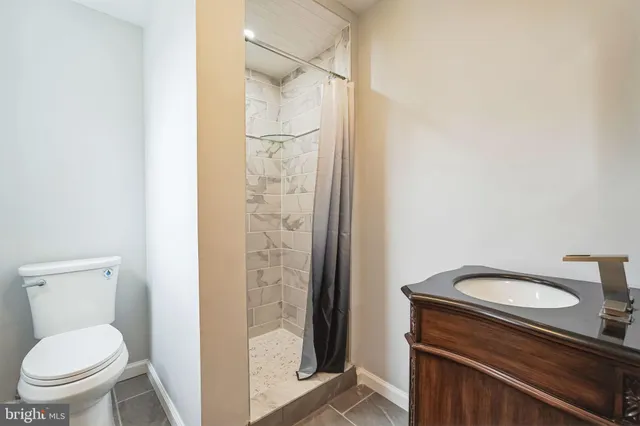 a bathroom with a granite countertop toilet and a shower