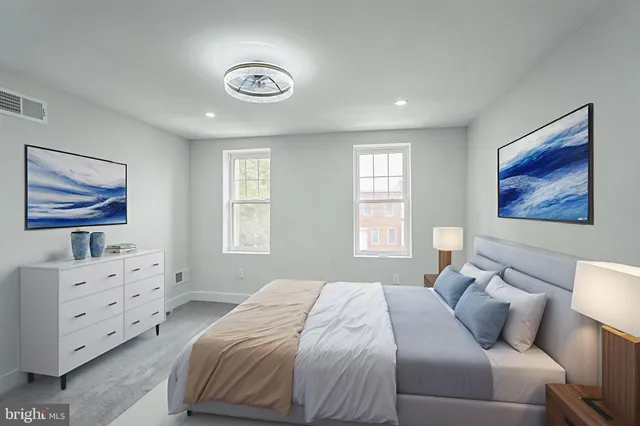 a bedroom with a bed and painting on the wall