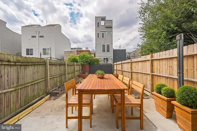 a view of a terrace with couches and wooden fence