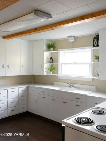 a kitchen with granite countertop white cabinets white stainless steel appliances with a sink and dishwasher