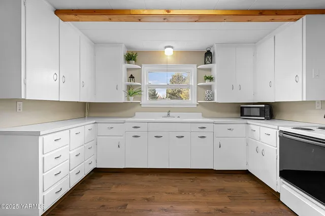 a sink with a window and cabinets