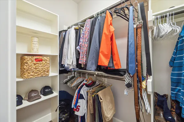 a view of walk in closet with clothes and shoes