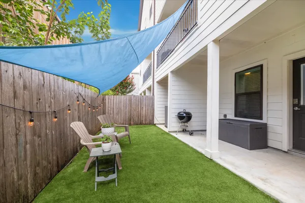 a view of a backyard with furniture and a garden