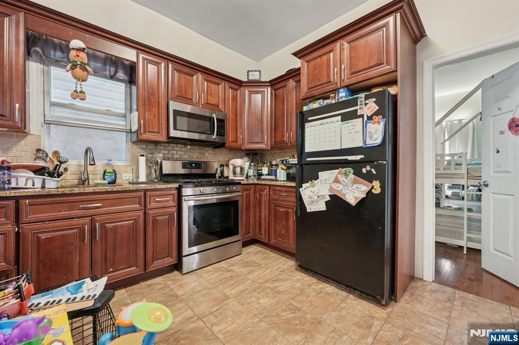 717 16th Street Union City, NJ 07087 - Photo 14 of 27 a kitchen with stainless steel appliances granite countertop a refrigerator stove and sink