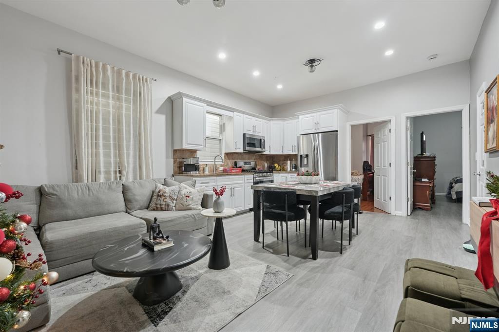 717 16th Street Union City, NJ 07087 - Photo 21 of 27 a living room with furniture and a dining table with kitchen view