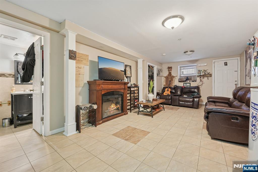 717 16th Street Union City, NJ 07087 - Photo 22 of 27 a living room with furniture a fireplace and a flat screen tv