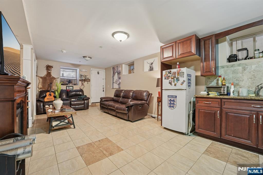 717 16th Street Union City, NJ 07087 - Photo 23 of 27 a living room with furniture a flat screen tv and a refrigerator