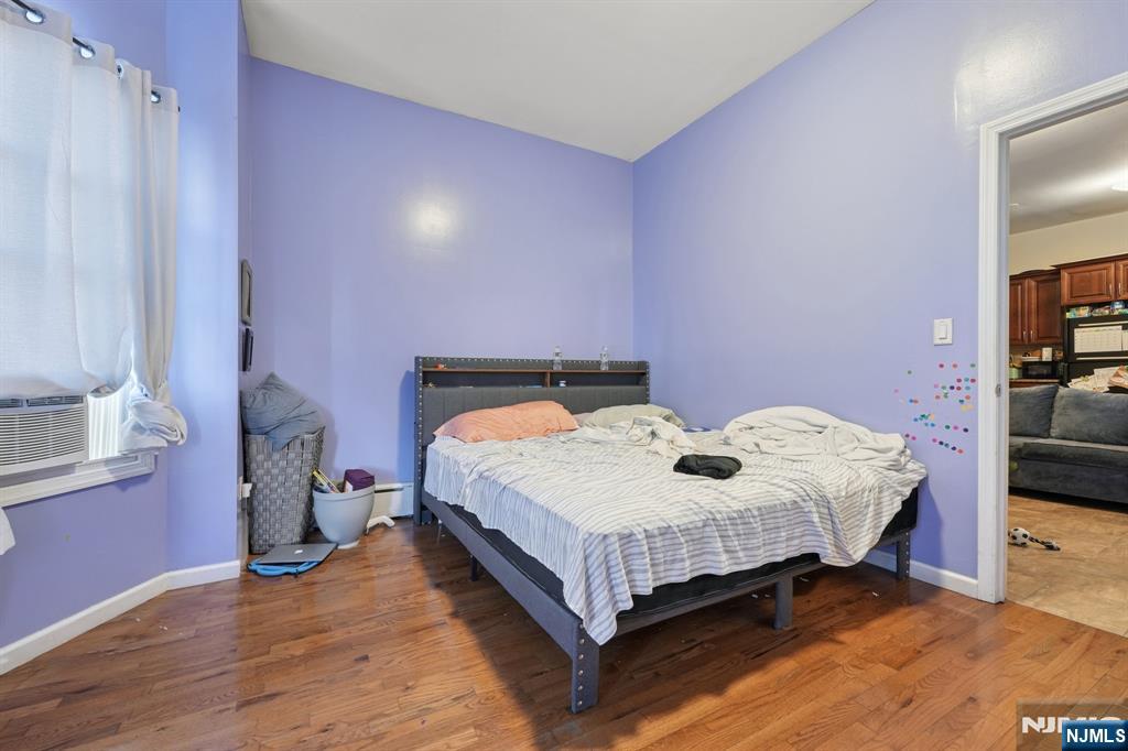 717 16th Street Union City, NJ 07087 - Photo 3 of 27 a bedroom with a bed and wooden floor