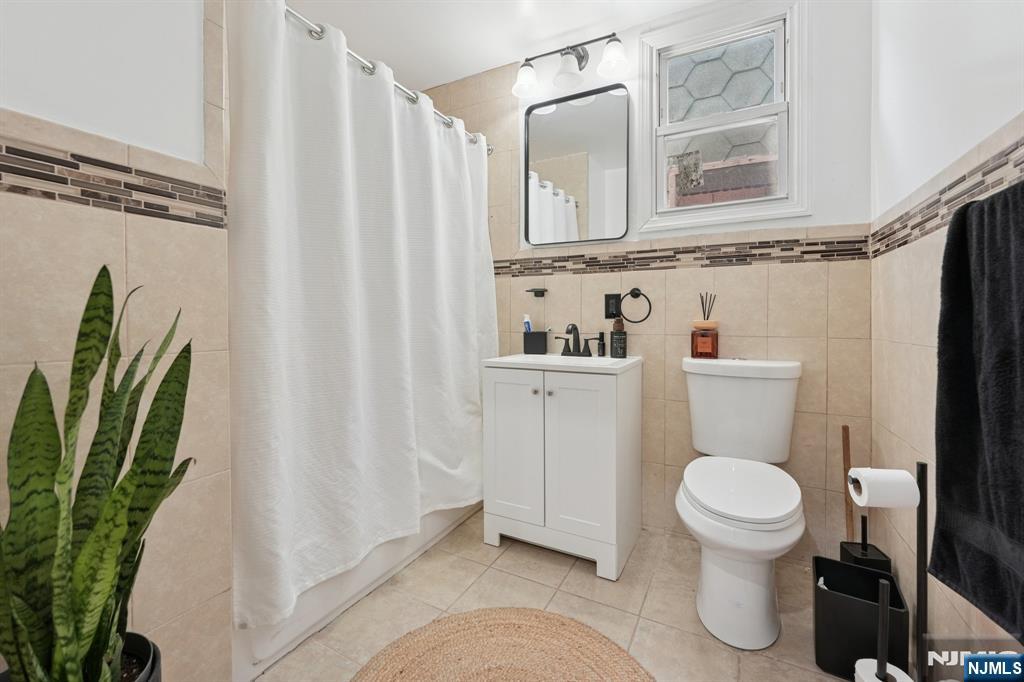 717 16th Street Union City, NJ 07087 - Photo 8 of 27 a bathroom with a toilet and a shower curtain