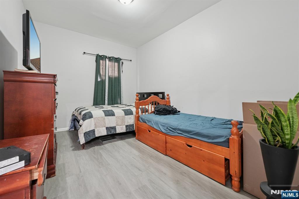 717 16th Street Union City, NJ 07087 - Photo 9 of 27 a bed room with a bed and a potted plant