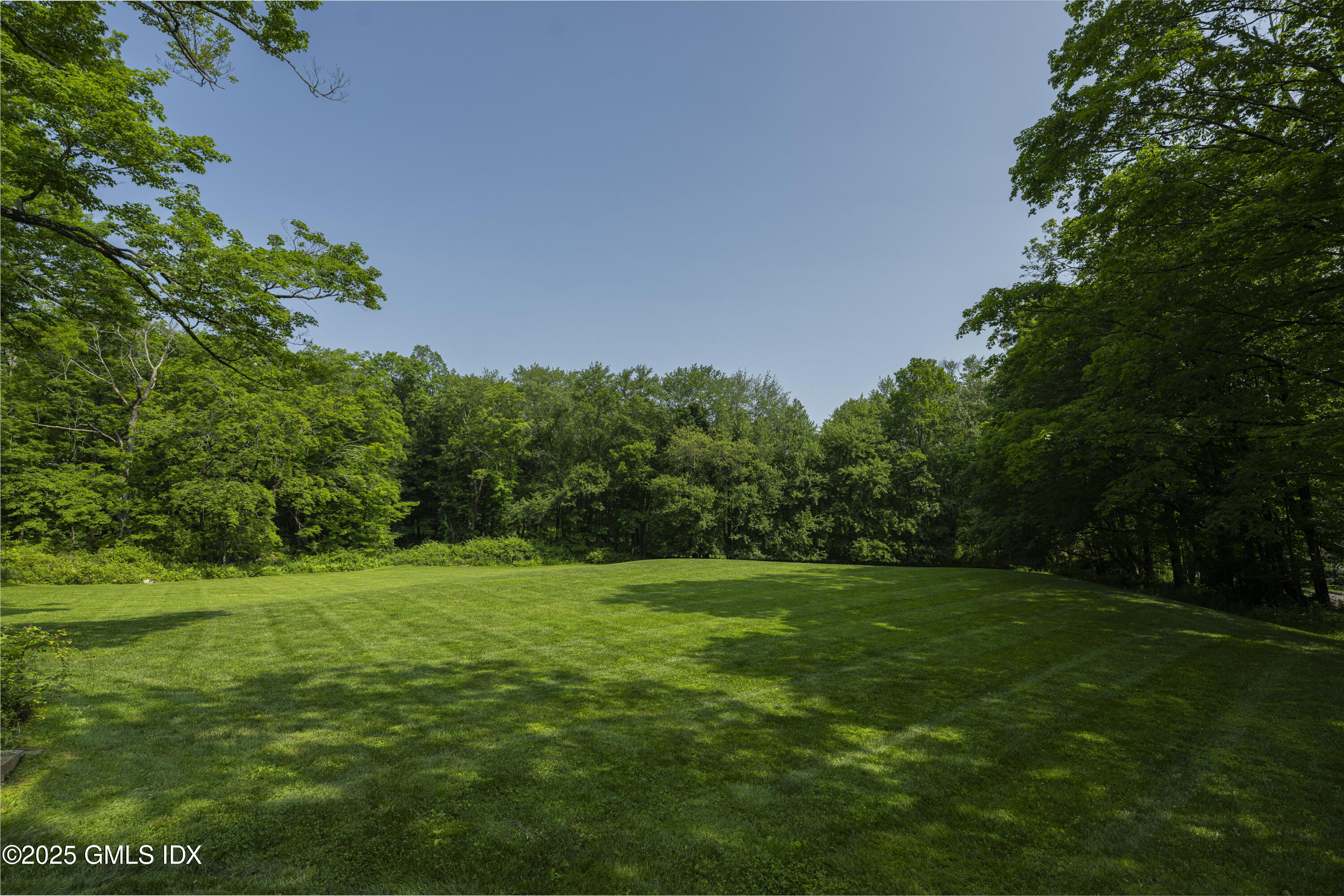 295 Taconic Road Greenwich, CT 06831 - Photo 24 of 35 a backyard of a house with lots of green space and garden