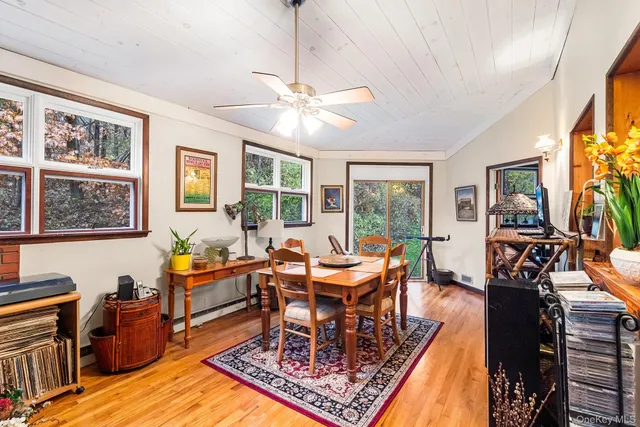 a dining room with wooden floor a chandelier a wooden table and chairs